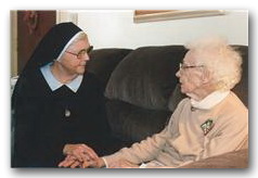 Sister holding the hand of an elderly woman
