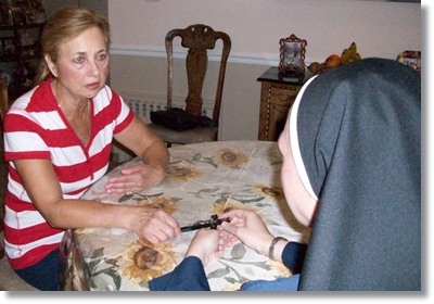 Sister talking to a woman at the table about the faith