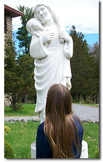 Young girl looking at statue of Good Shepherd