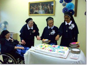 Sister gathered around their jubilee cake